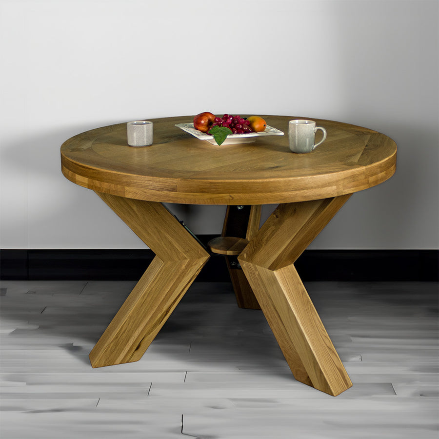Front of the smooth natural oak stained Amstel Round Oak Dining Table with two coffee mugs and a fruit platter on top.