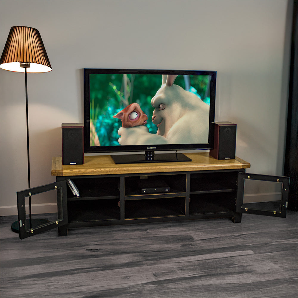 An overall view of the Cascais 2 Door Medium Entertainment Unit with its doors open. There is a large TV with two speakers on either side. There is a DVD player in the top shelf in the middle and two DVDs in the right shelf.