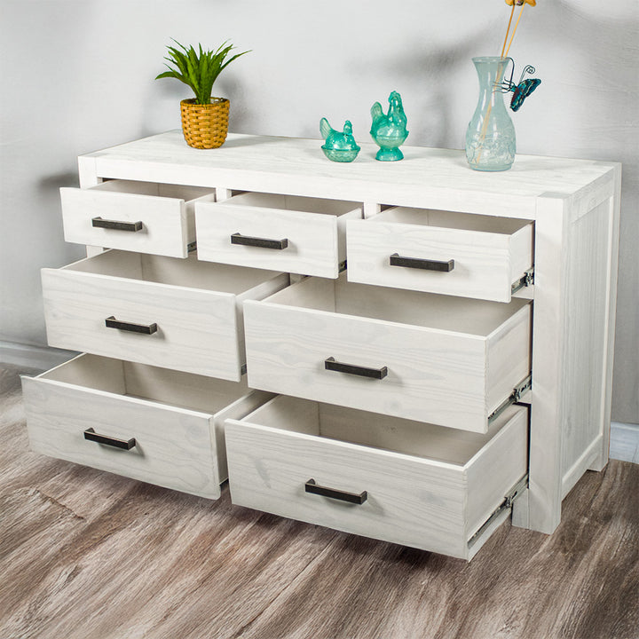 The Vancouver 7 Drawer White Lowboy with its drawers open. There is a potted plant and three blue glass ornaments on top.