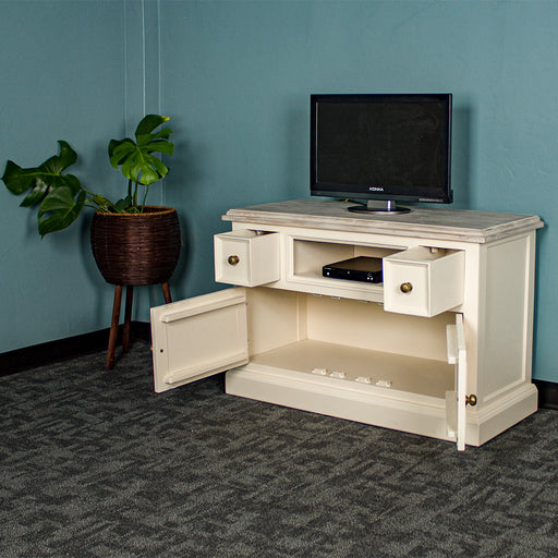 The front of the Biarritz Compact TV Unit with its drawers open. There is a DVD player in the middle shelf and a small TV on top. There is a free standing potted plant next to the unit.