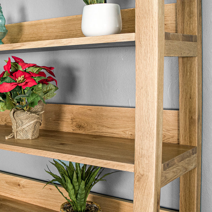 A close up of the side of the Kubic Oak Display Shelf. There is a bundle of red flowers on the shelf.