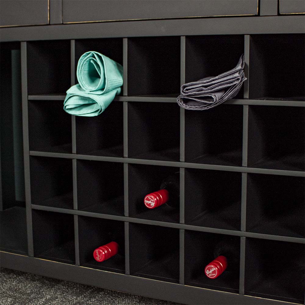 A closer view of the Cascais Large Buffet's wine rack. There are three wine bottles in the bottom shelves and two towels in the top.