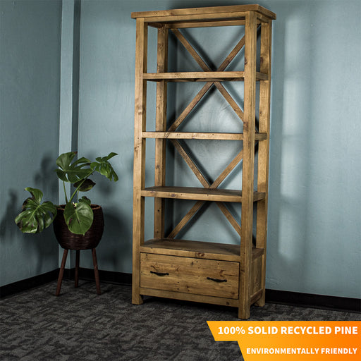 The light brown Ventura Recycled Pine Bookcase, with a standing potted plant next to it. There is text in the corner that says "100% Solid Recycled Pine" and "Environmentally Friendly"