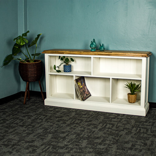 The front of the Versailles Outback Oak Bookshelf (Off White). There are two blue glass ornaments on top. There is a potted plant on the top left shelf, a set of vinyl records on the middle lower shelf and a potted plant on the bottom right shelf. There is a free standing potted plant next to the bookcase.