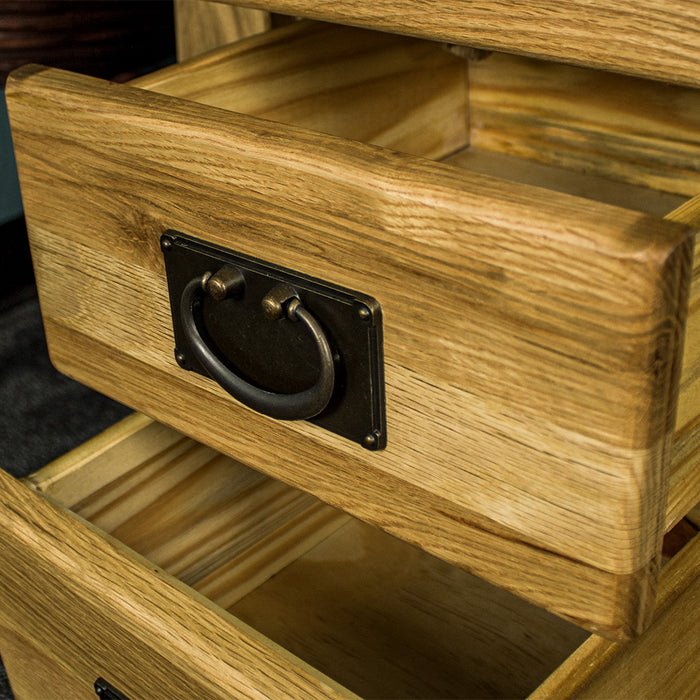 A close up on the round hanging handle on the drawers of the Amstel Oak Bedside Table.