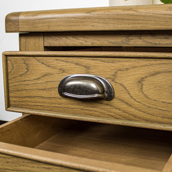 A close up of the brushed silver coloured circular metal handle on the drawers of the Houston Oak Lamp Table
