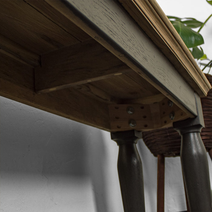 A view of under the Boston Short Oak Bench, showing the bolts that securely hold the legs of the Boston Short Oak Bench to the body.