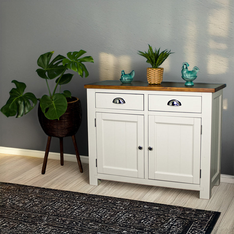 The front of the Alton 2 Door 2 Drawer NZ Pine Buffet. There are two potted plants on top with a free standing potted plant to the left of the sideboard.
