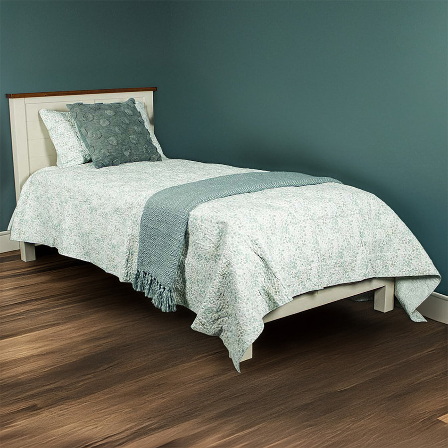 The front of the Alton King Single NZ Pine Slat Bed Frame. It is dressed in blankets and pillows.