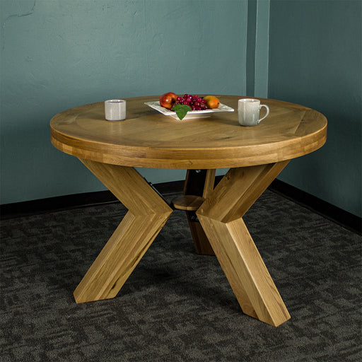 Front of the smooth natural oak stained Amstel Round Oak Dining Table with two coffee mugs and a fruit platter on top.