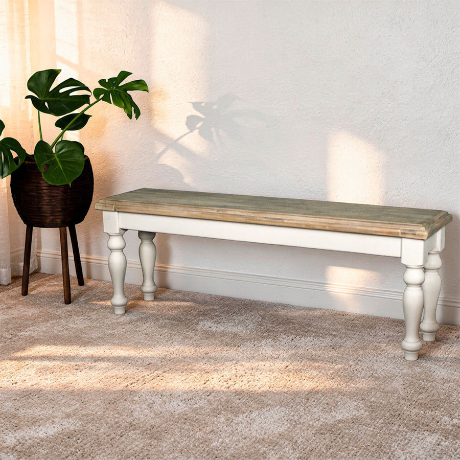An overall view of the Biarritz 1.4m Bench. There is a free standing potted plant next to it.