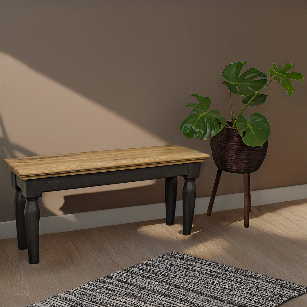 An overall view of the Boston Short Oak Bench. There is a free standing potted plant next to it.