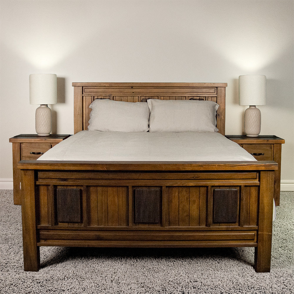 The front of the Botanica Queen Slat Bed Frame, dressed in sheets and pillows.
