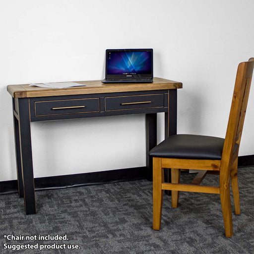 The front of the Cascais Black Desk. There is a laptop and papers on top of the desk and a upholstered pine dining chair in front of the desk.