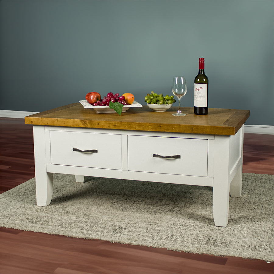 The front of the Felixstowe Coffee Table, which is sitting on a rug. There are two fruit platters, a wine glass and a wine bottle on top.