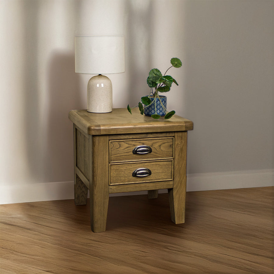 The front of the Houston Oak Lamp Table. There is a lamp and a potted plant on top.