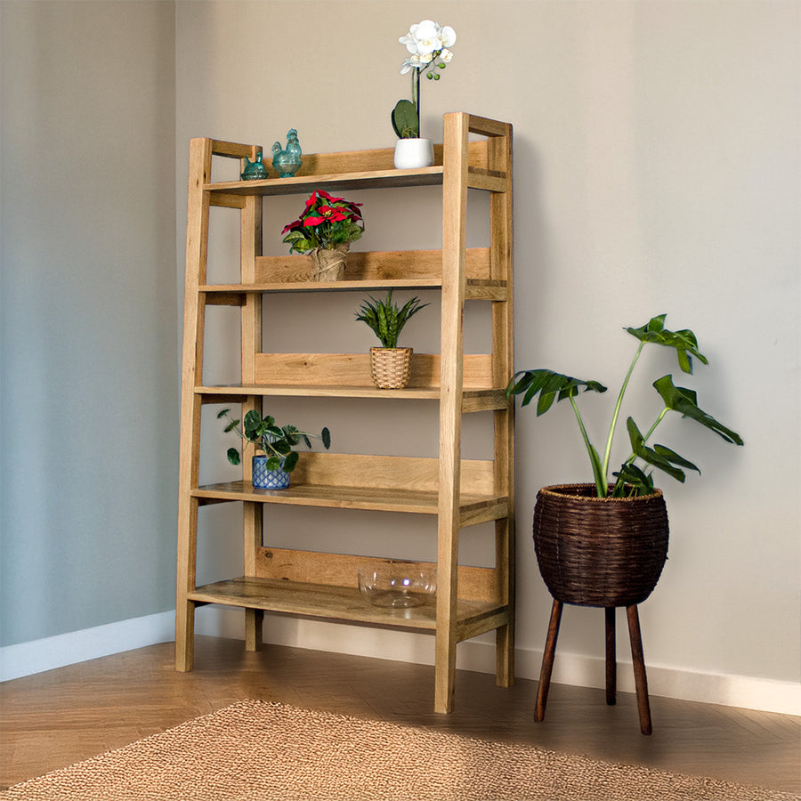 The front of the Kubic Oak Display Shelf. There are two blue glass ornaments and a pot of white flowers on the top shelf, a bundle of red flowers on the second shelf, a potted plant on the third shelf, a potted plant on the fourth shelf and a glass bowl on the fifth shelf. There is a free standing potted plant next to the shelf.