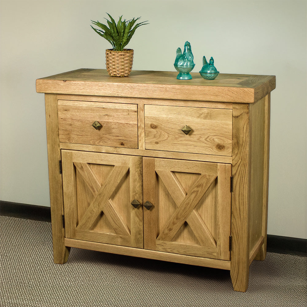The front of the Maximus Small Oak Buffet. There is a potted plant and two blue glass ornaments on top.