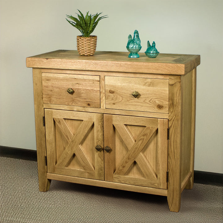 The front of the Maximus Small Oak Buffet. There is a potted plant and two blue glass ornaments on top.
