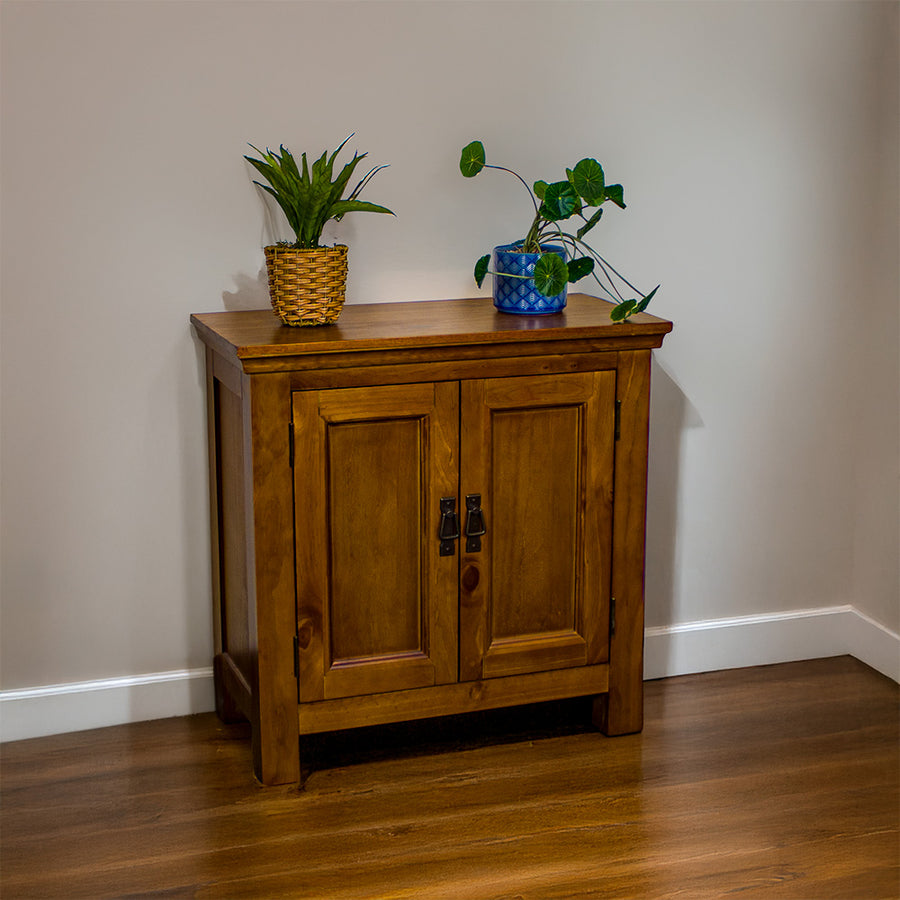 The front of the Montreal Compact Pine Buffet. There are two potted plants on top.