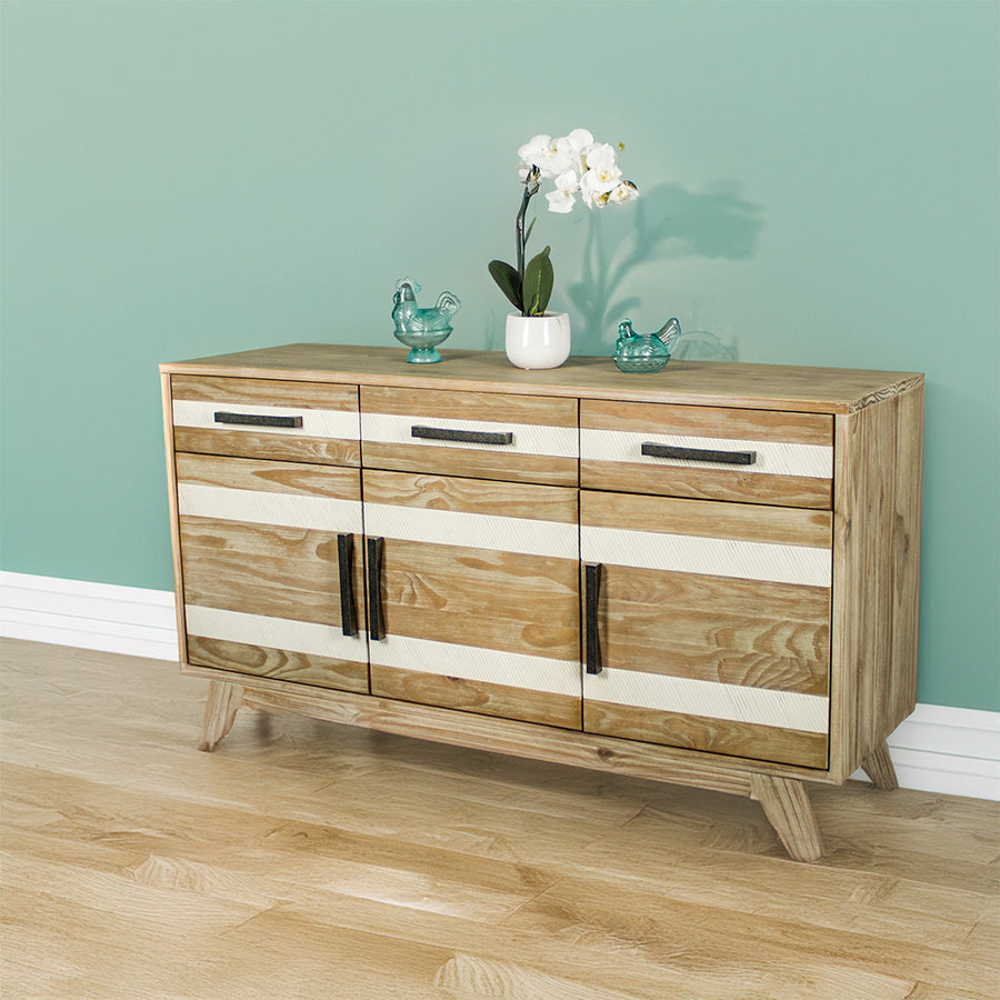 The front of the Soho 3 Drawer NZ Pine Large Buffet. There are two blue glass ornaments on top with a pot of white flowers in between.