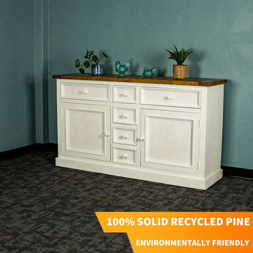 The front of the Tuscan Recycled Pine Buffet. There are two potted plants on top and two blue glass ornaments as well.