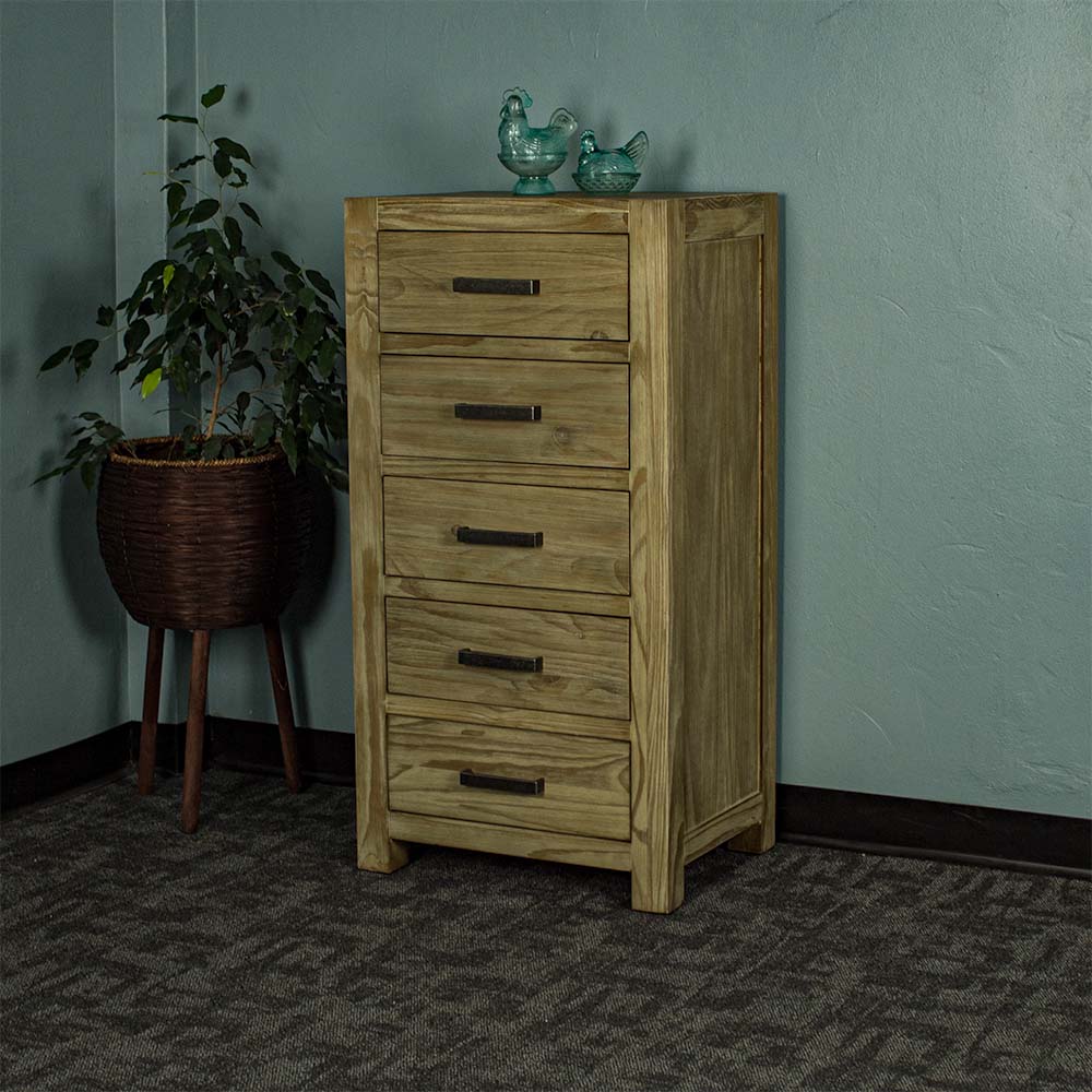 The front of the Vancouver 5 Drawer NZ Pine Lingerie Chest. There are two blue glass ornaments on top and a free standing potted plant to the left.