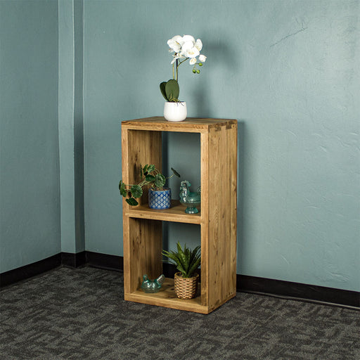 The front of the Vancouver Value Double Cube Oak Shelf with a white pot of white flowers on top, a potted plant and blue glass ornament on the top shelf and a blue glass ornament and potted plant on the bottom shelf.