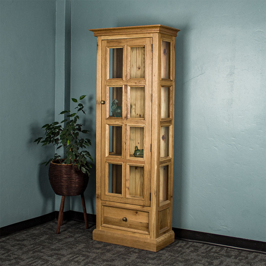 The front of the Versailles Small Display Cabinet. There are two blue glass ornaments that can be seen from the windows and a tall free standing potted plant next to  the cabinet.