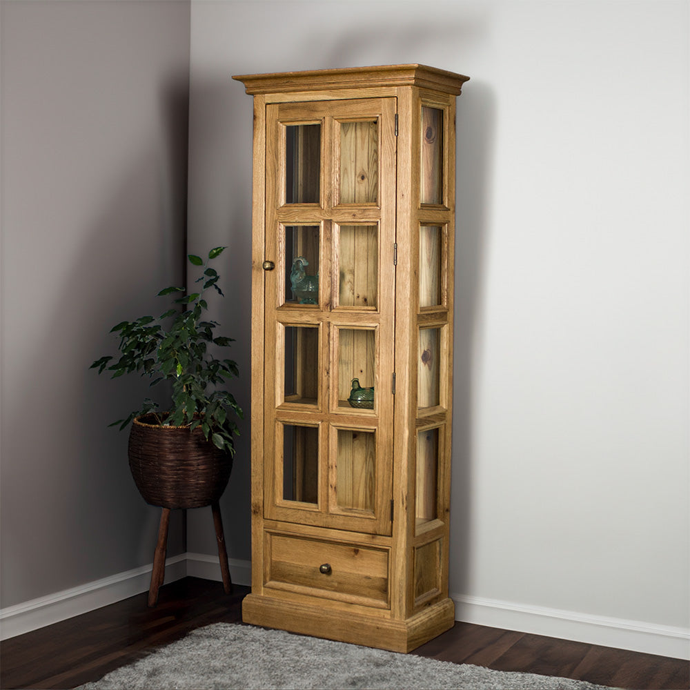 The front of the Versailles Small Display Cabinet. There are two blue glass ornaments that can be seen from the windows and a tall free standing potted plant next to the cabinet.