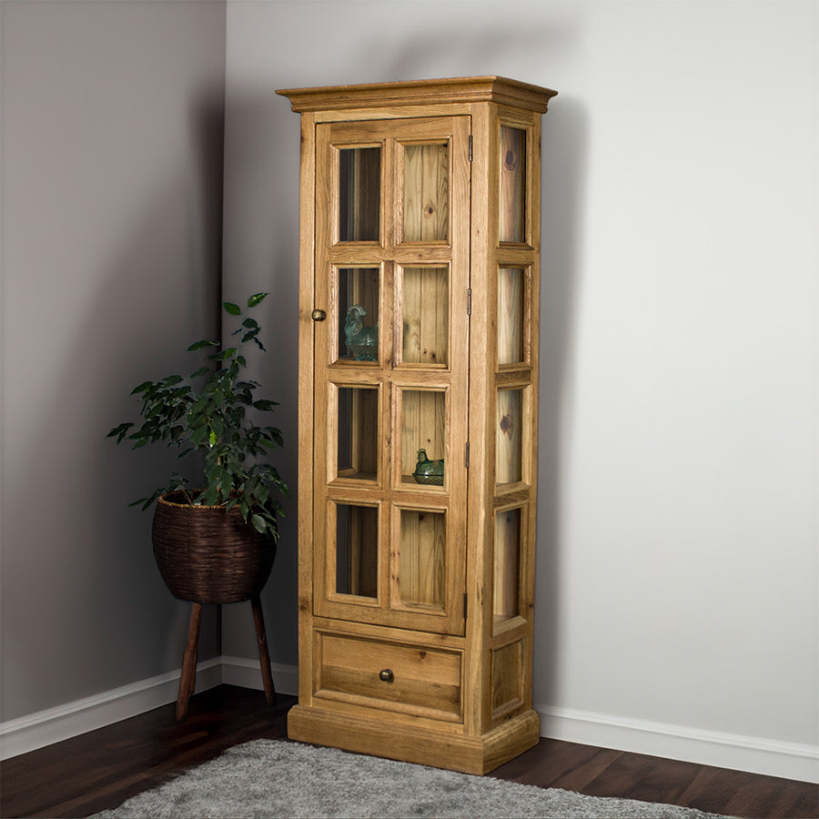 The front of the Versailles Small Display Cabinet. There are two blue glass ornaments that can be seen from the windows and a tall free standing potted plant next to the cabinet.