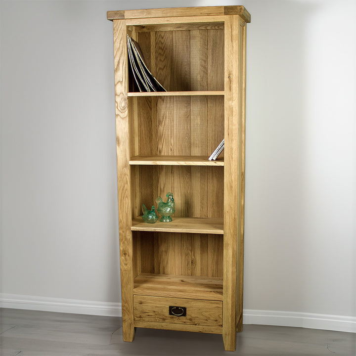 The front of the Yes Tall Oak Bookcase. There are a stack of vinyl records, two dvd cases and two glass blue ornaments on the shelves.
