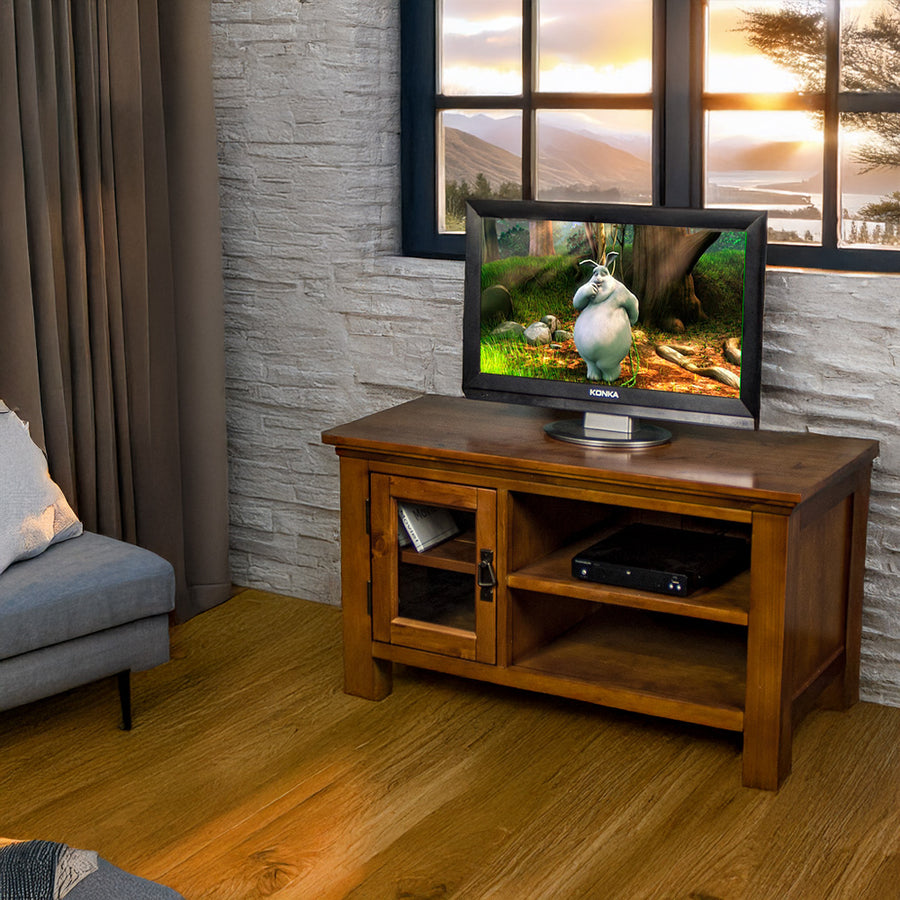 The front of the Montreal Small Entertainment Unit, with a small TV on top. There is a DVD player on the top shelf, and a free standing potted plant next to the unit.