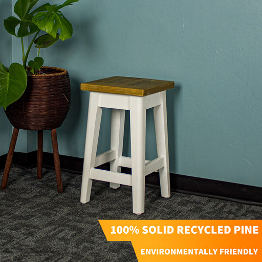 An overall view of the Byron Recycled Pine Stool. There is a free standing potted plant next to the stool.