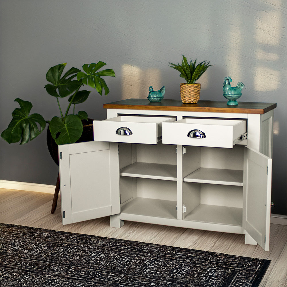 The front of the Alton 2 Door 2 Drawer NZ Pine Buffet with its drawers and doors open. There are two potted plants on top with a free standing potted plant to the left.
