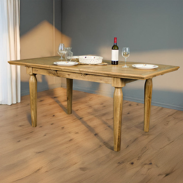An overall view of the Boston Oak Extending Dining Table - Natural Oak extended, with kitchenware, plates and glasses on top.