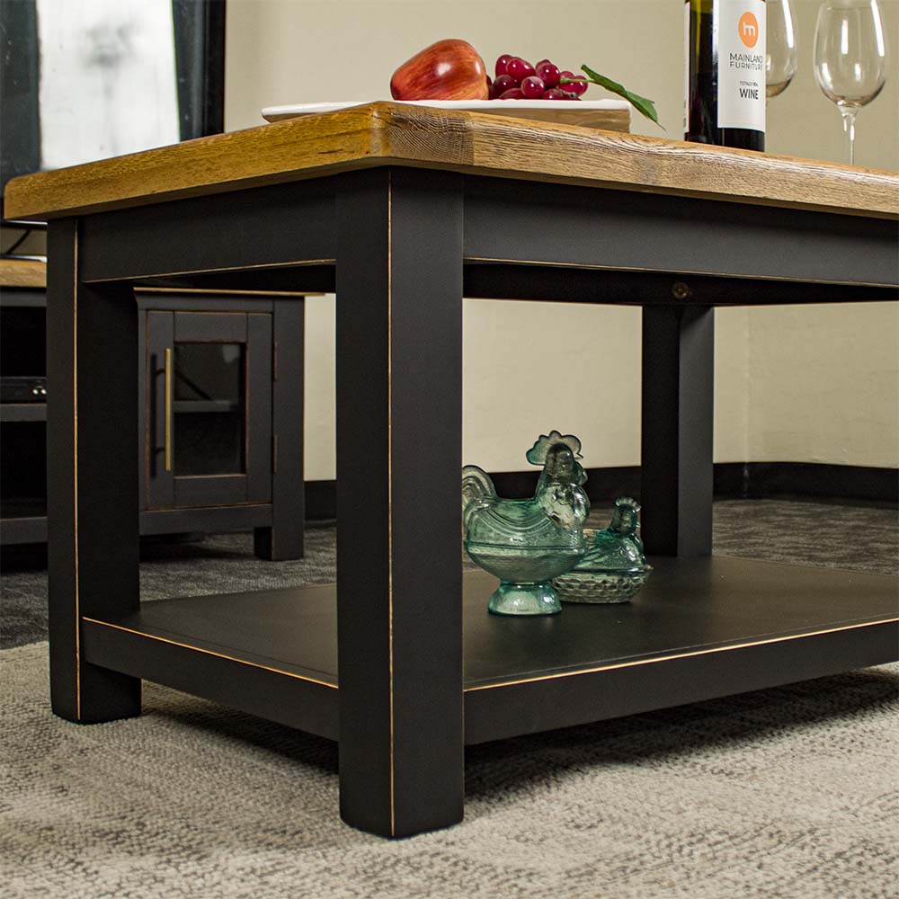 A view of the shelf under the Cascais Oak-Top Coffee Table. There are two blue glass ornaments in the shape of chickens.