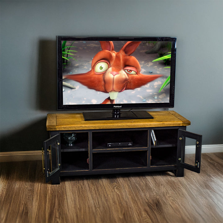 The front of the Cascais Oak-Top TV Unit with its doors open. There is a large TV on top with a DVD player on the top drawer in the middle.