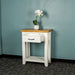 Front of the white Felixstowe Small Pine Hall Table with its drawer open. There is a small pot of white flowers on top.