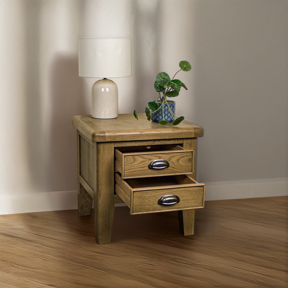 The front of the Houston Oak Lamp Table with its drawers open. There is a lamp and a potted plant on top.