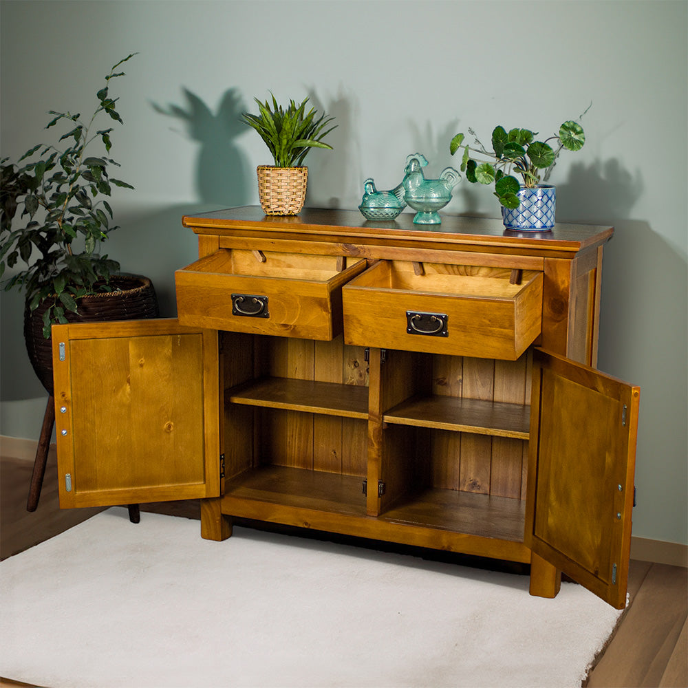 The front of the Rimu stained Montreal 2 Drawer Pine Buffet with its doors and drawers open. There are two potted plants on top, with two blue glass ornaments on top.