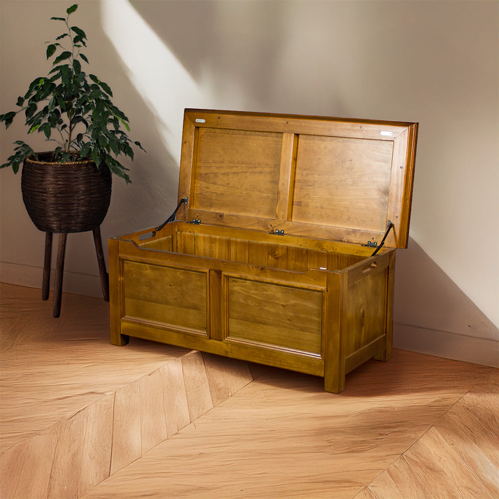 The front of the Montreal Pine Blanket Box, which is open. There is a free standing potted plant next to it.