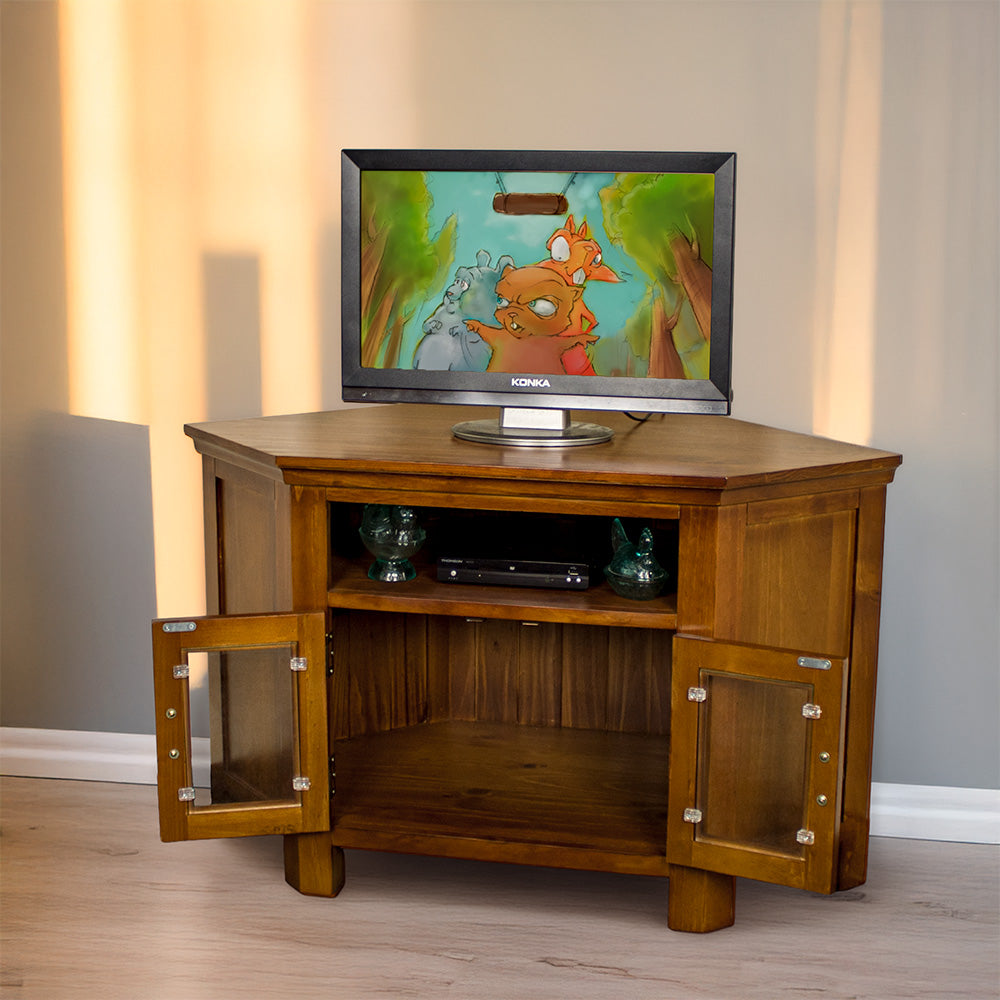 The front of the Montreal Pine Corner Entertainment Unit with its doors open. There is a TV on top, and two blue glass ornaments with a DVD player in between on the top shelf.