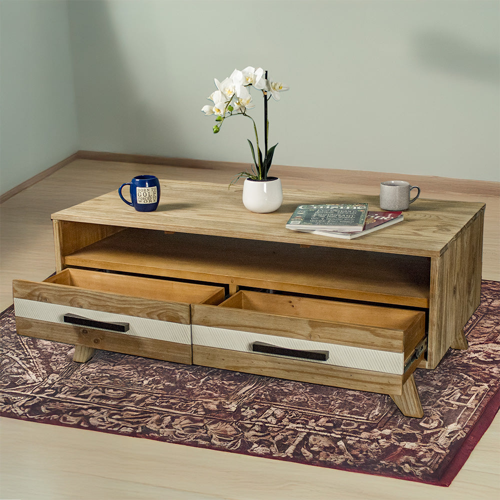 The front of the Soho 4 Drawer NZ Pine Coffee Table with its drawers open. There are two coffee mugs, two magazines and a small pot of white flowers on top of the table.

