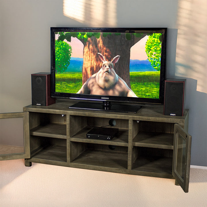 The front of the Stonemill Recycled Pine TV Unit with its doors open and a TV and two speakers on top. There is a DVD player in the top shelf in the middle.