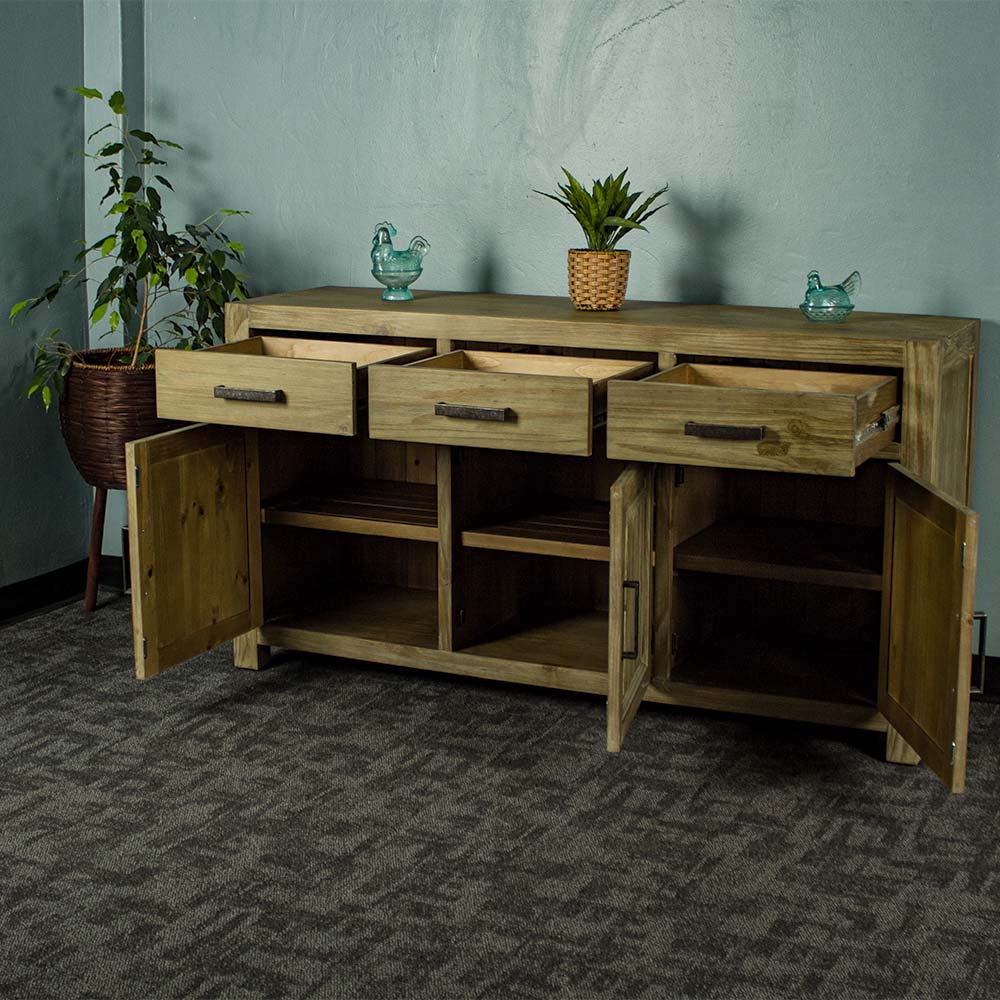 The front of the Vancouver Large NZ Pine Buffet with its drawers and doors open. There are two blue glass ornaments on top with a potted plant in the middle. There is a free standing potted plant next to the sideboard.