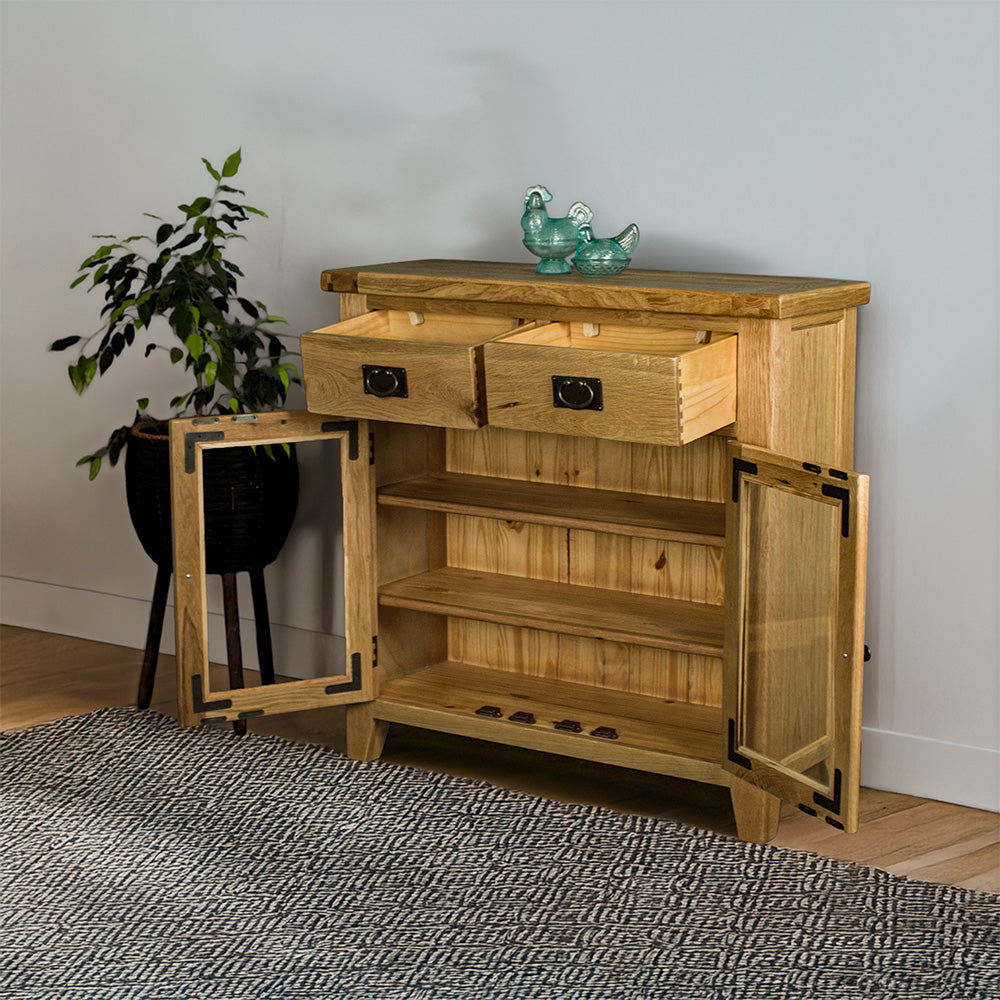 The front of the Vancouver Value 2 Drawer 2 Door Oak Sideboard, with its drawers and doors open. There are two blue glass ornaments on top and a free standing potted plant next to the buffet.