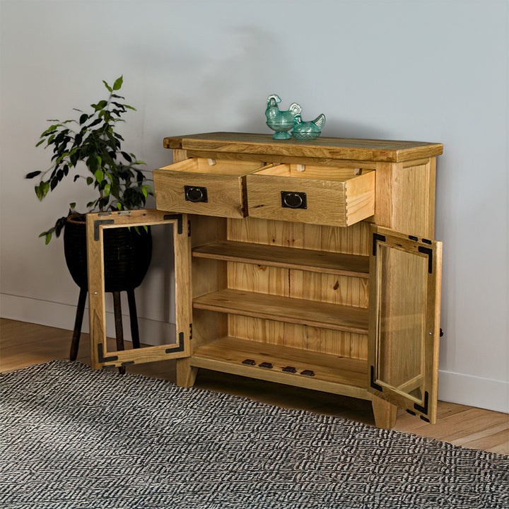 The front of the Vancouver Value 2 Drawer 2 Door Oak Sideboard, with its drawers and doors open. There are two blue glass ornaments on top and a free standing potted plant next to the buffet.