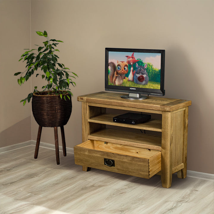 The front of the Vancouver Value Oak Entertainment Unit with its drawer open. There is a DVD player on the top shelf and a free standing potted plant next to the TV unit.