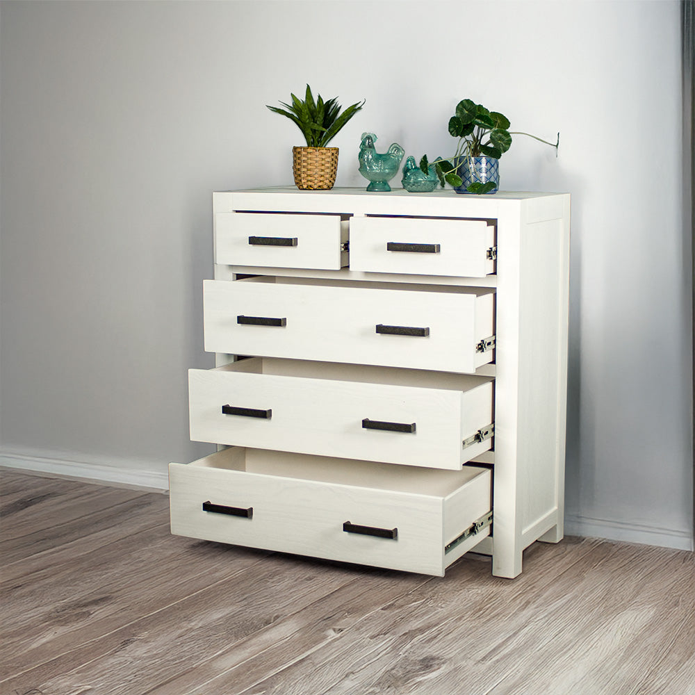Vancouver Five Drawer White NZ Pine Tallboy with its drawers open. There are two potted plants and two blue glass ornaments on top.